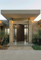 Custom cast aluminium pivot door with geometric line design, partially open at modern Australian luxury home entrance
