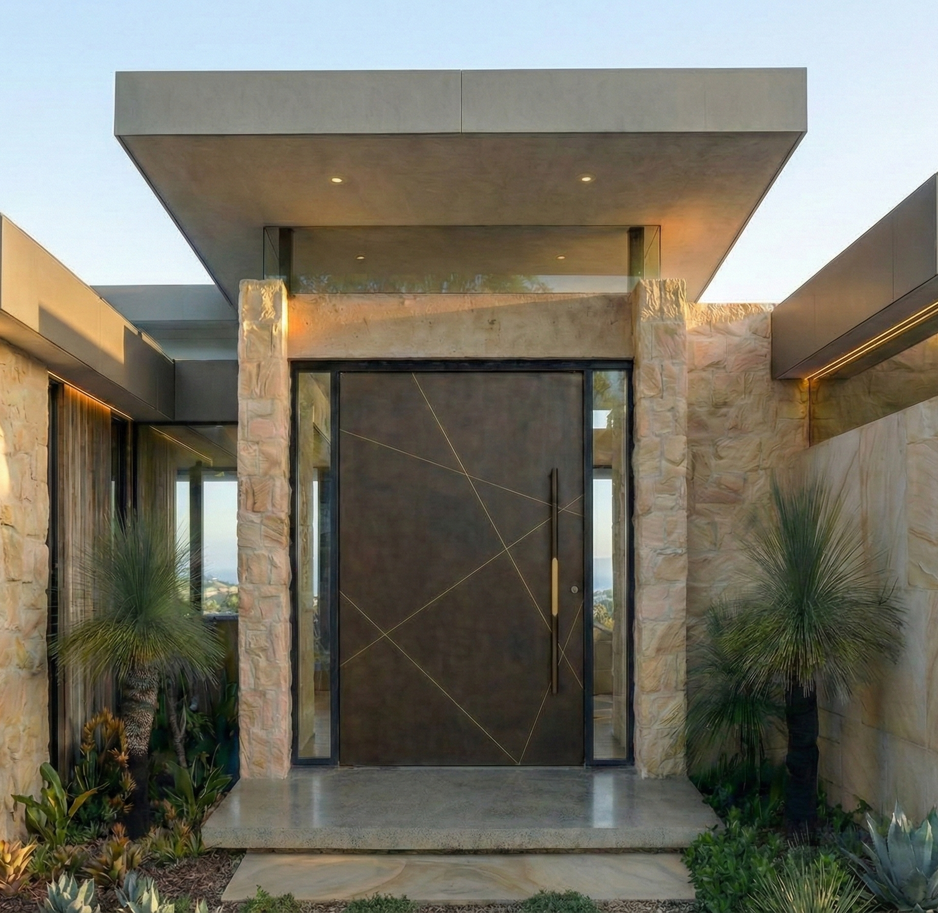 Full-height cast aluminium pivot door with geometric pattern at modern Australian architectural entrance
